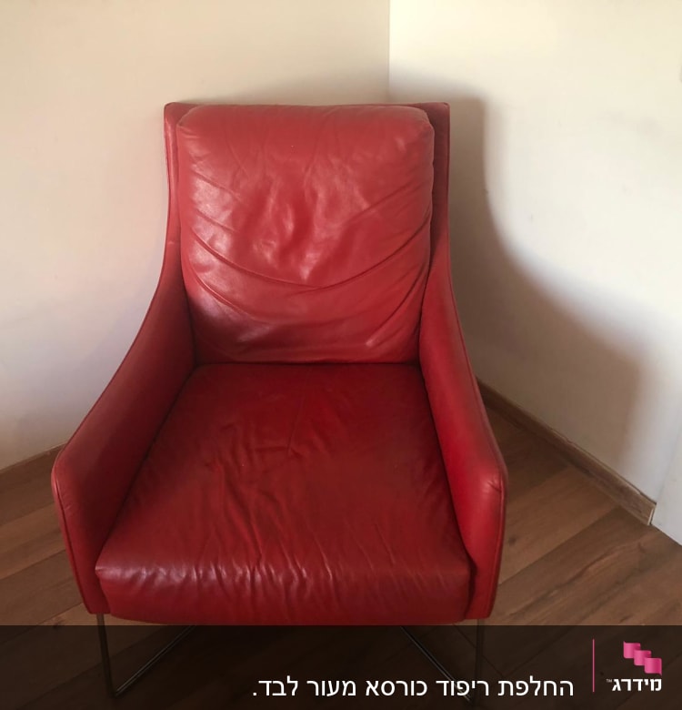 כורסה אדומה עם ריפוד עור על רצפת עץ